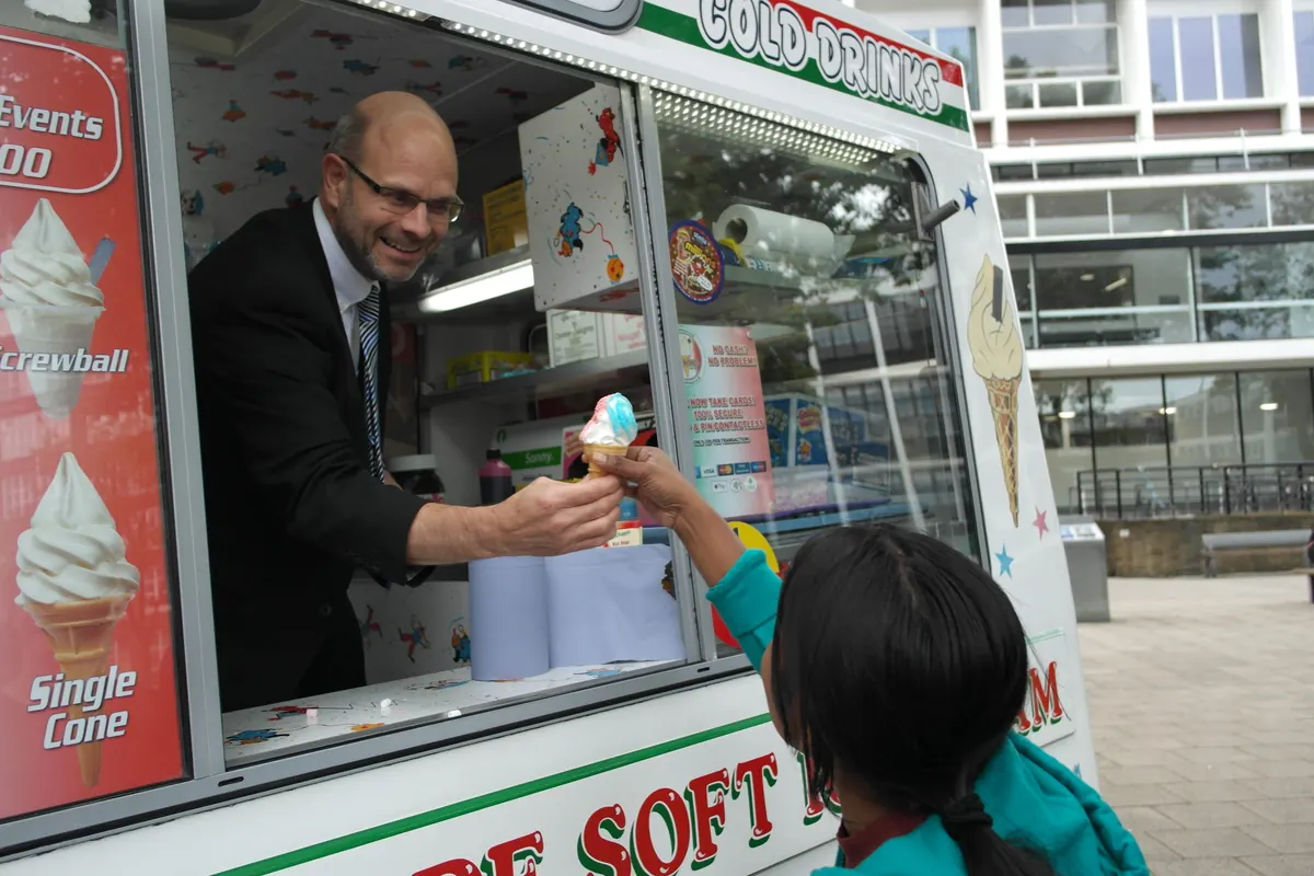 A guest being handed an ice cream from the Austins Ices van