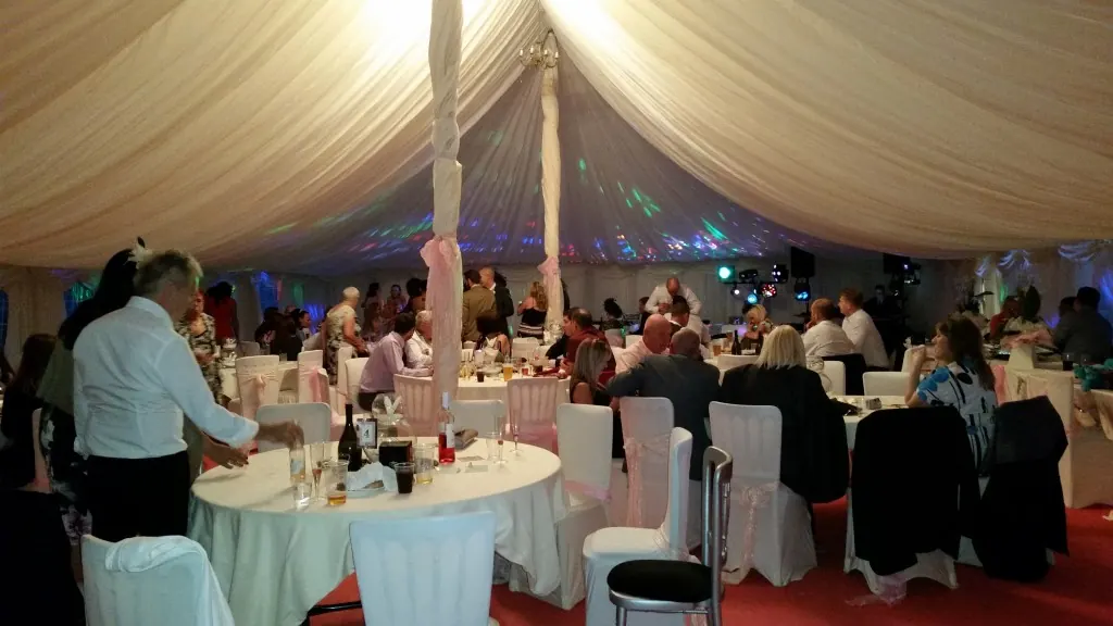 Wedding guests in the marquee at a surprise reception in Tabley, Cheshire