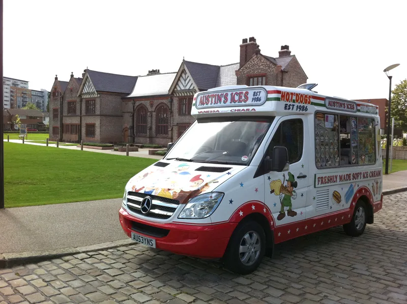 Excited children and parents queuing up at an Austins Ices van during a school sports day fete